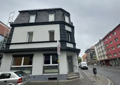 Frisch gestrichene Altbaufassade in Schwarz-Weiß nach Malerarbeiten