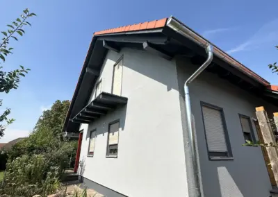 Neu gestrichene Fassade mit abgesetztem Sockel an einem Einfamilienhaus