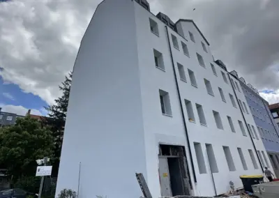 Weiß gestrichenes Mehrfamilienhaus nach Abschluss der Malerarbeiten
