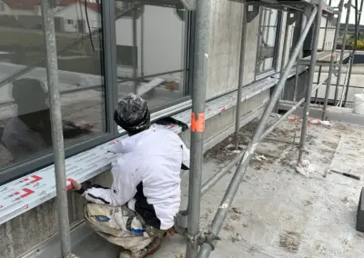 Maler bei Detailarbeiten an der Fassade auf dem Gerüst